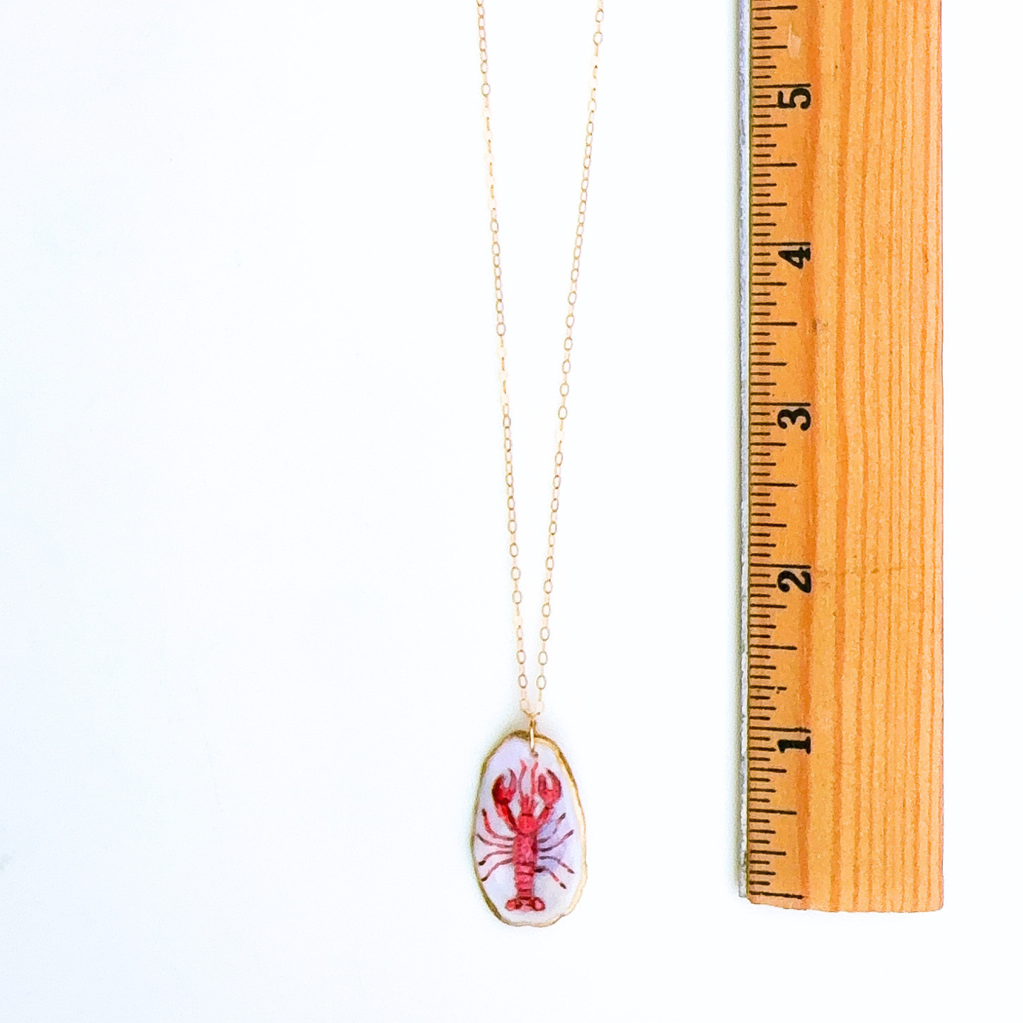 Red lobster motif oyster shell necklace shown in gift-ready packaging
