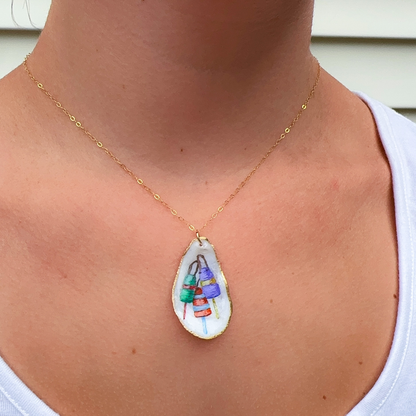 Close-up of hand-painted buoy design on a coastal oyster shell necklace pendant