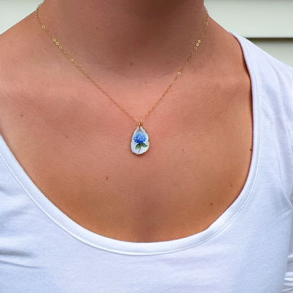 Close-up of hand-painted hydrangea design on a coastal oyster shell necklace pendant