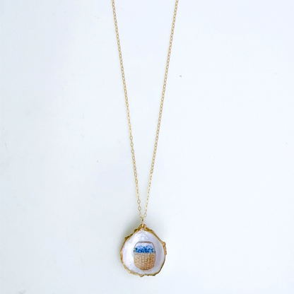 One-of-a-kind Nantucket basket oyster shell necklace styled on a neutral background
