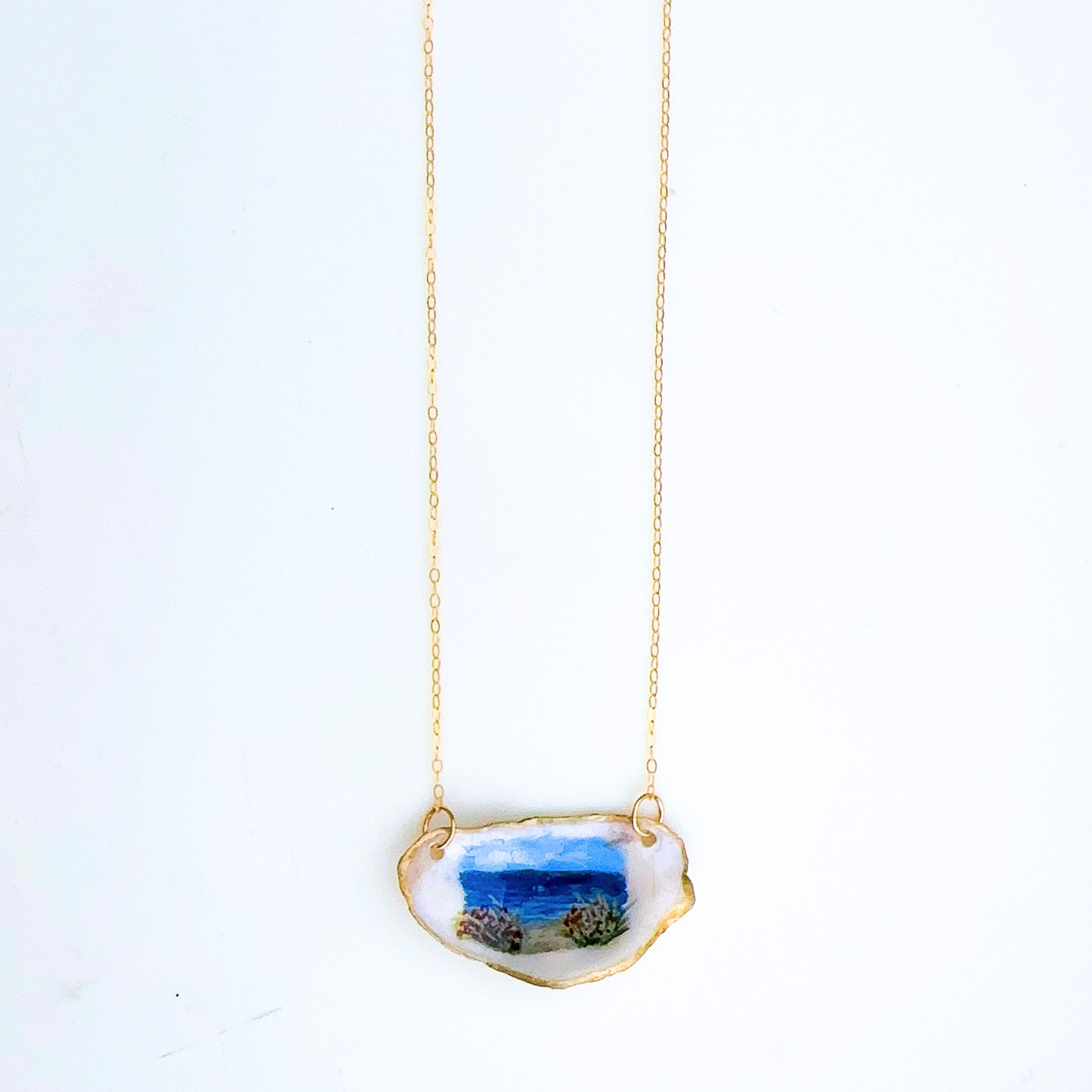 One-of-a-kind beach roses oyster shell necklace styled on a neutral background