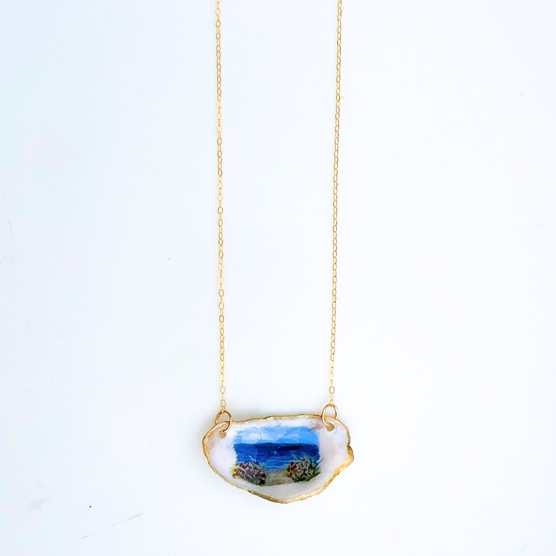 One-of-a-kind beach roses oyster shell necklace styled on a neutral background