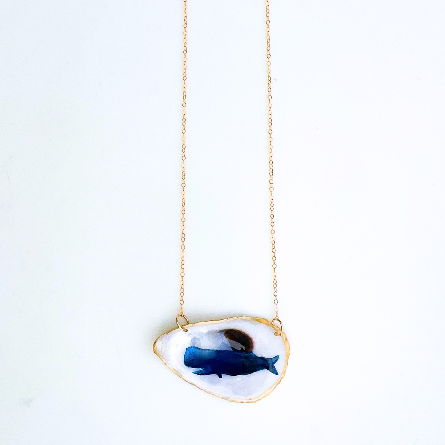One-of-a-kind whale motif oyster shell necklace styled on a neutral background