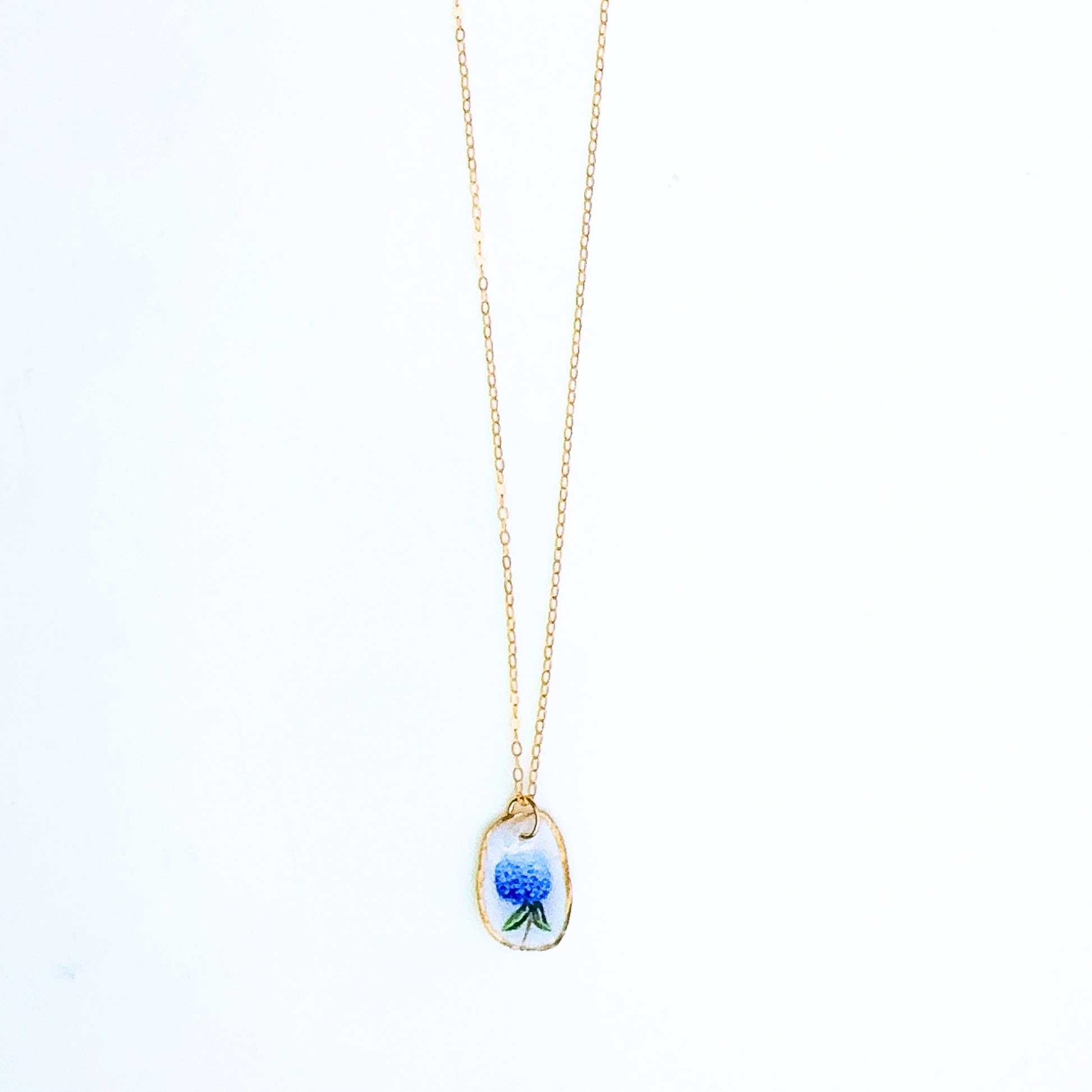 One-of-a-kind hydrangea oyster shell necklace styled on a neutral background