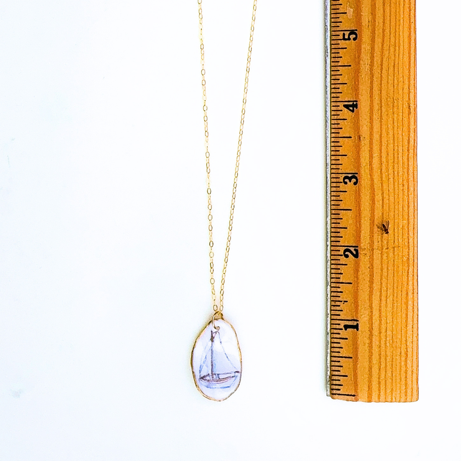 Sailboat motif oyster shell necklace shown in gift-ready packaging