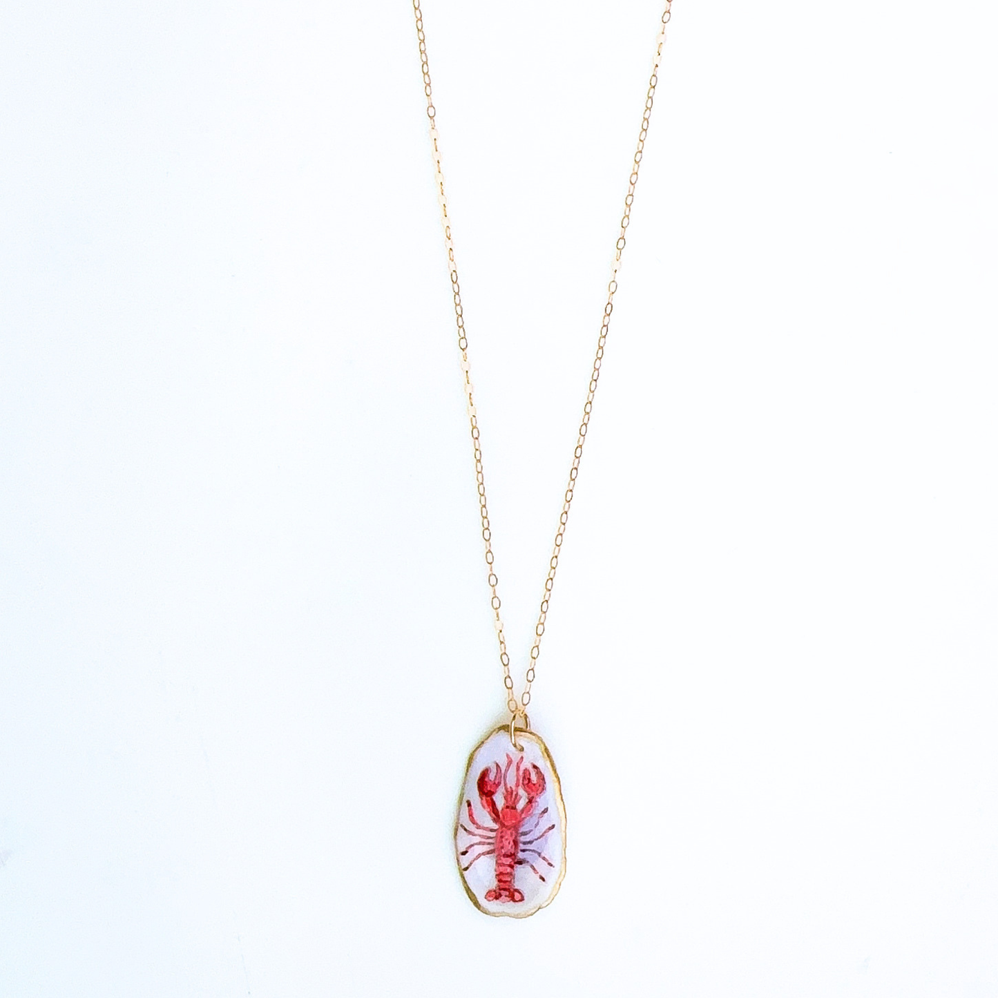 One-of-a-kind red lobster oyster shell necklace styled on a neutral background