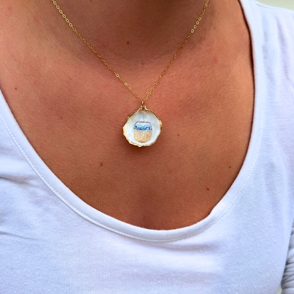 Close-up of hand-painted Nantucket basket design on a coastal oyster shell necklace pendant